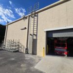 Commercial fixed steel access ladder installed on an industrial building for safe rooftop maintenance access.