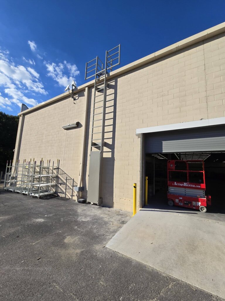 Commercial fixed steel access ladder installed on an industrial building for safe rooftop maintenance access.