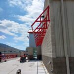 Custom steel canopy frame installation on a commercial building exterior for covered walkway and structural expansion.