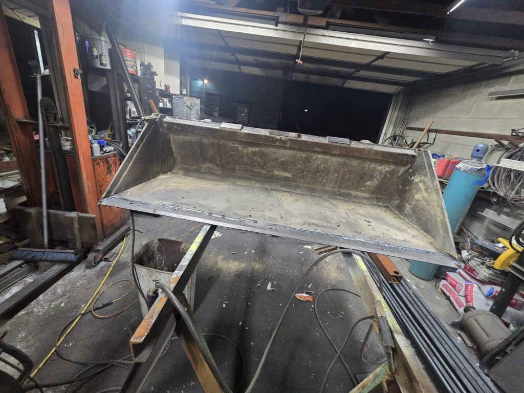 Custom steel equipment bucket being welded and fabricated in a welding shop in Pennsylvania