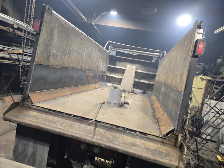 Custom fabricated steel dump truck bed built and welded for heavy duty hauling and industrial applications.