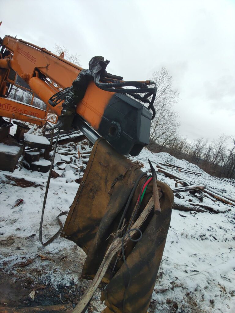 Heavy equipment bucket repair and welding service performed on an excavator attachment for industrial construction equipment.