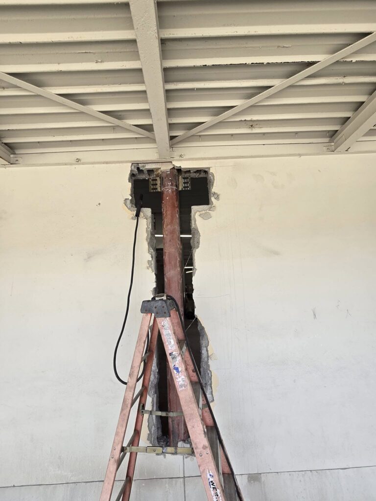 Structural steel column installation through an existing concrete wall during a commercial building reinforcement project in Pennsylvania.