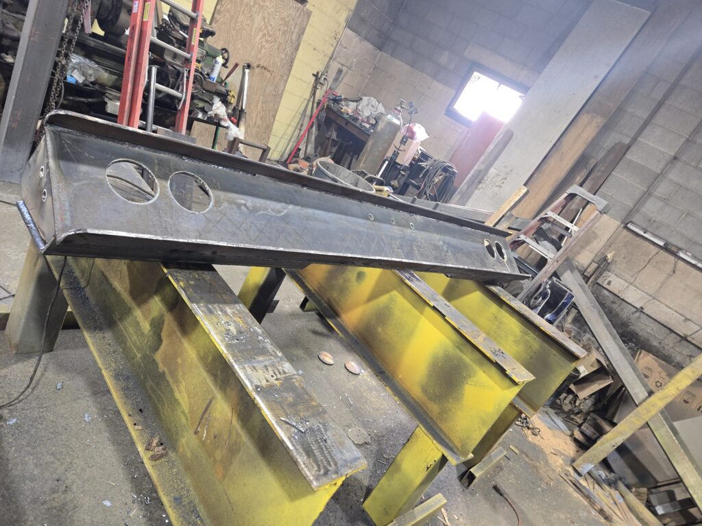 Custom heavy steel beam fabrication with drilled plates in metal shop