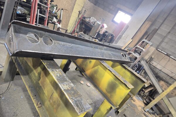 Custom heavy steel beam fabrication with drilled plates in metal shop