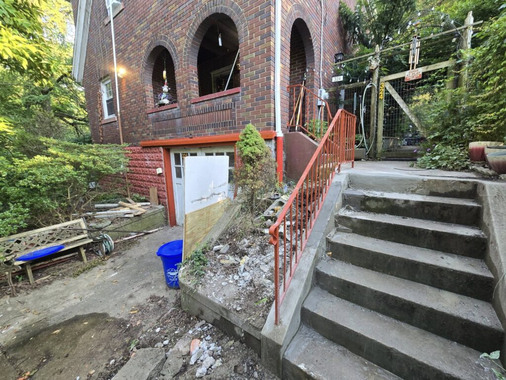 Custom steel staircase railing installation at residential brick home in Pennsylvania