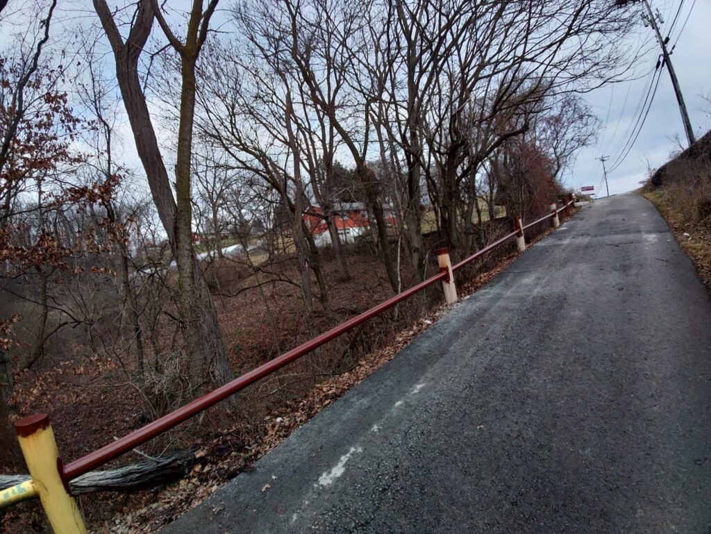 Custom steel guardrail installed along hillside roadway