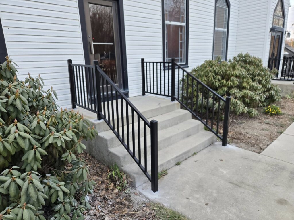 Custom black steel stair railing installation at residential entrance in Pennsylvania