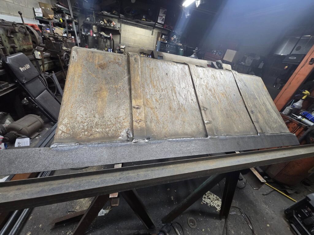 Heavy steel plate section being cut and prepared on fabrication table in welding shop in Pennsylvania