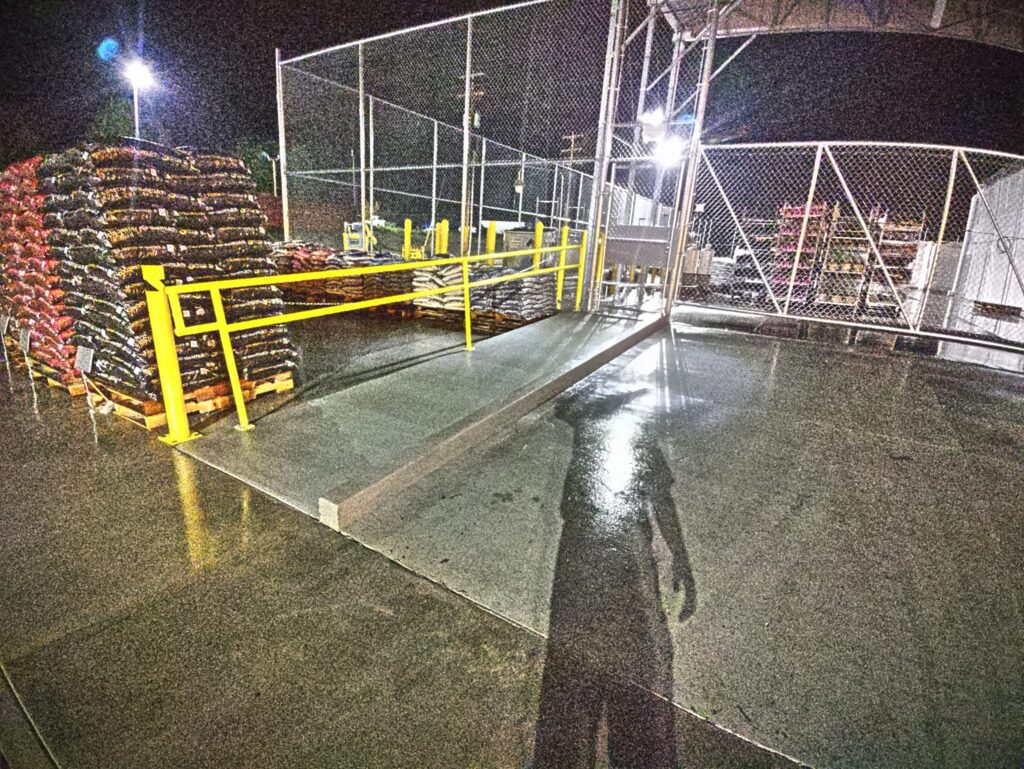 Industrial safety railing installed beside concrete loading ramp