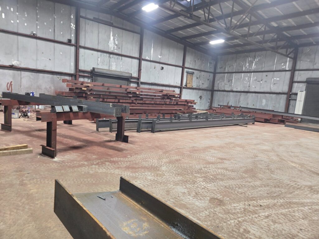 Structural steel beams fabricated and prepared inside industrial shop