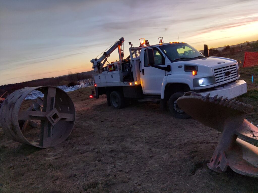 Mobile welding service truck at construction site with large steel components