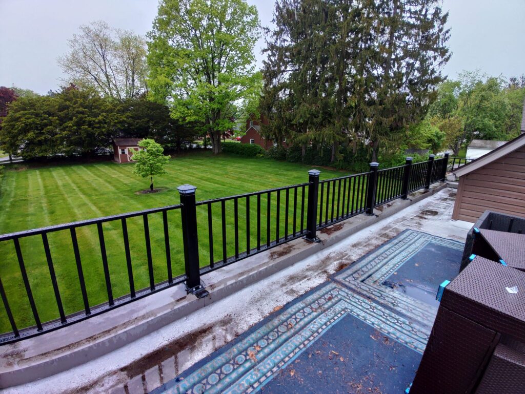 Residential black steel fence installed along backyard terrace in Pennsylvania