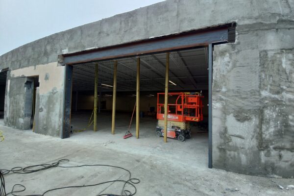 Structural steel header installation for a commercial building renovation creating a new large span storefront opening.
