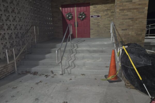 Custom steel handrail installation on concrete church entrance stairs to improve safety and accessibility.