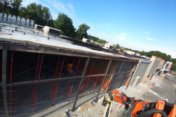 Structural steel framing installation for a commercial building expansion project with aerial lift access equipment.