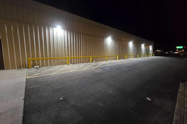 Yellow steel safety guardrail installed along a commercial warehouse exterior in Pennsylvania.